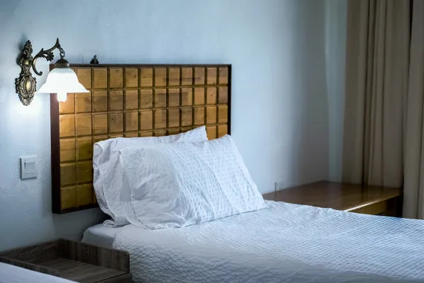 A soft, neatly made bed suggesting a calmer evening reset.