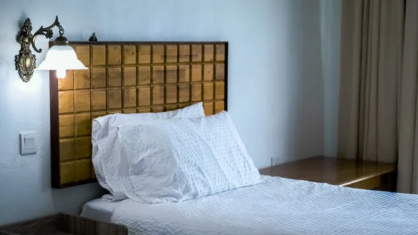 A soft, neatly made bed suggesting a calmer evening reset.