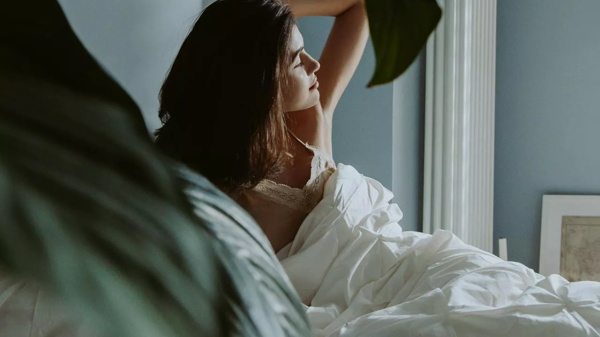 A person in bed looking awake and tired.